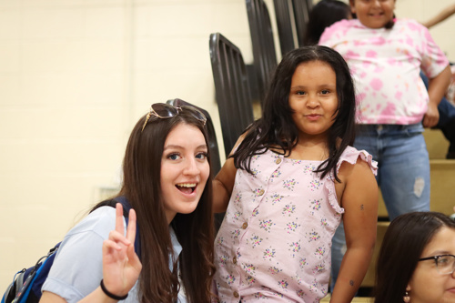 Photo of UCC Volunteer Corps student smiling with a young female student