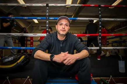 Photo of Boxing Coach Angel Villerreal sitting in a boxing ring