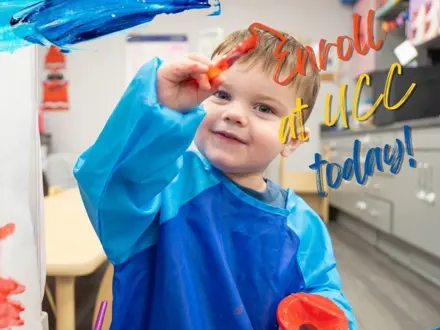 Little Boy wearing a blue smock and painting